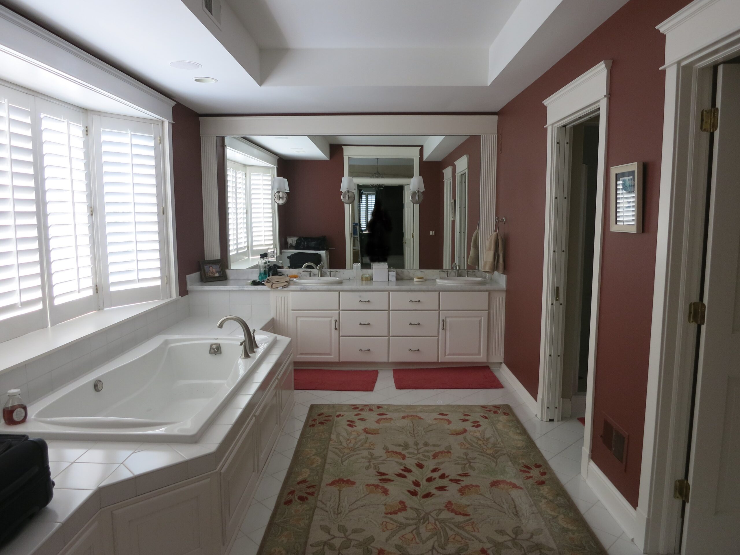 Original bathroom with red walls and outdated features.
