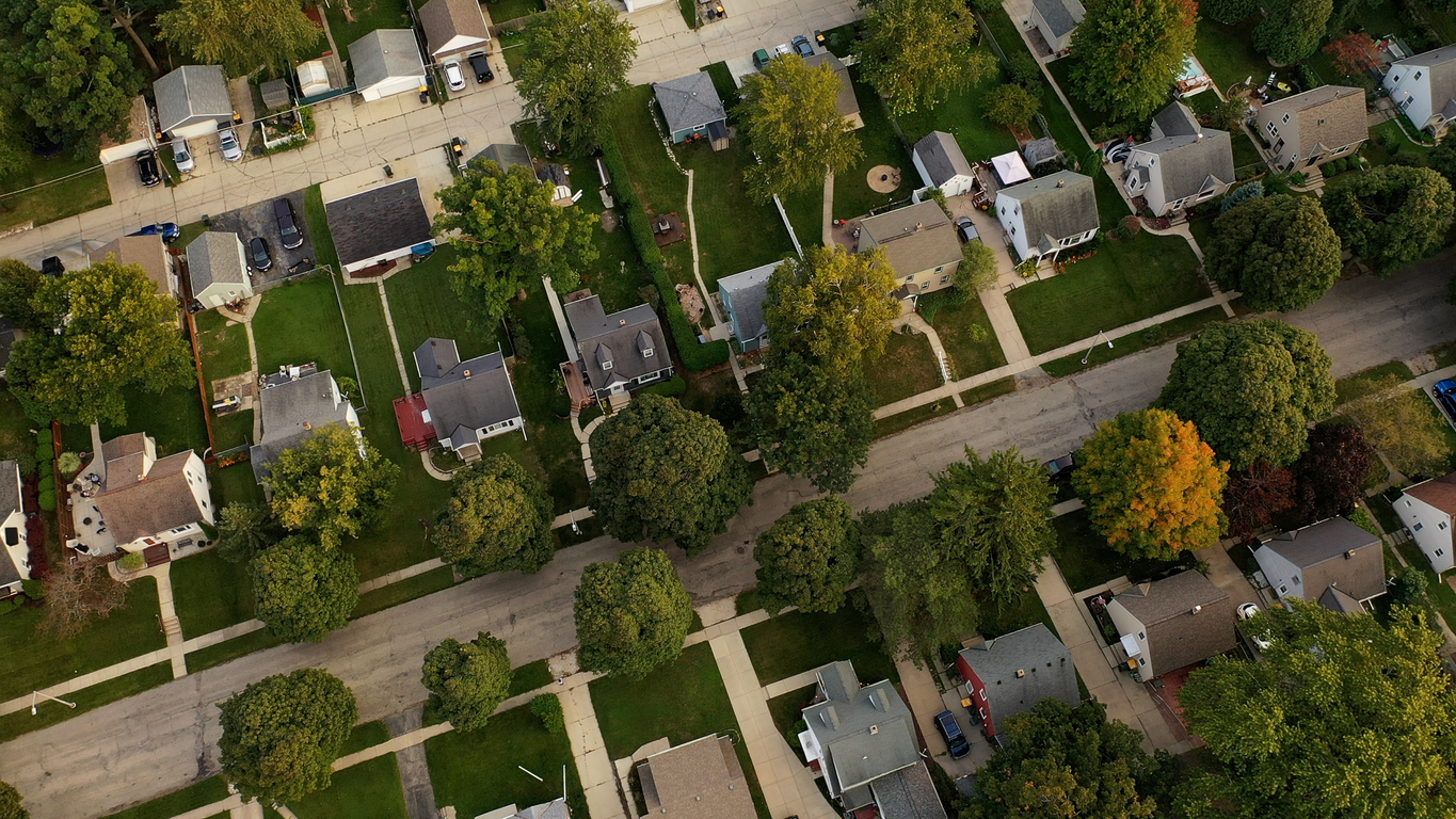 Aerial drone view of American suburban neighborhood at daytime. Establishing shot of America's suburb. Residential single family houses pattern