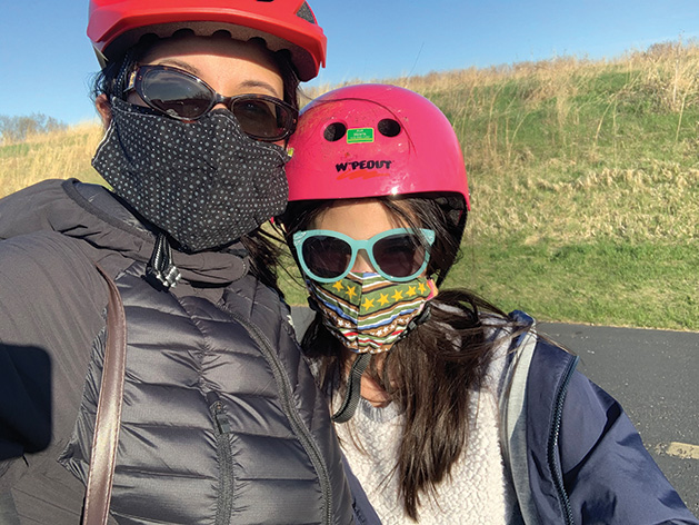 Mother and daughter wearing bike helmets.