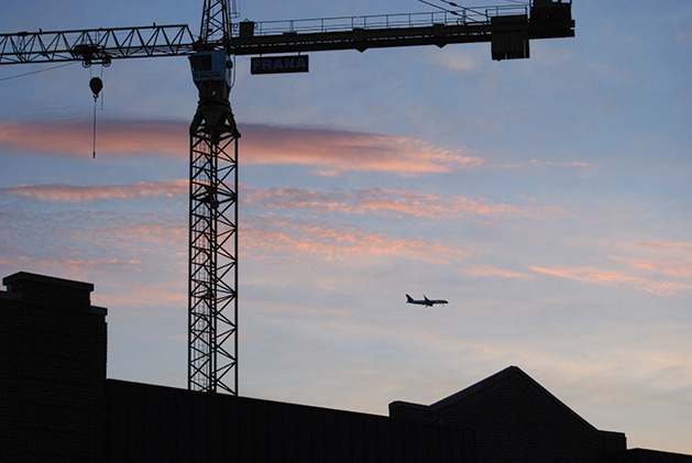 A plane flies past the Nolan Mains construction site in Edina.