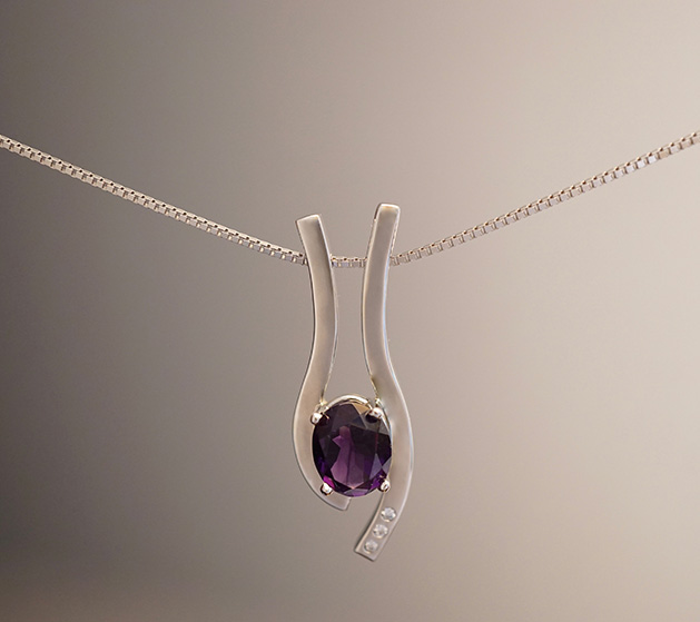 Silver jewelry necklace with purple stone.