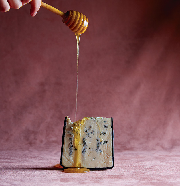 Honey drizzled on a block of cheese.