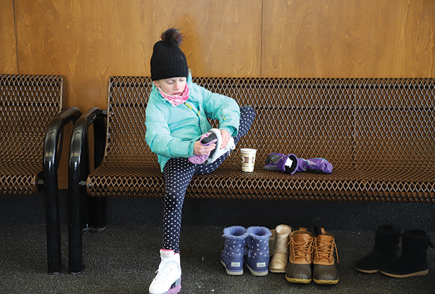 A child puts on skates at the Pamela Park warming house.