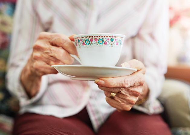 A woman drinks tea at a Memory Cafe event