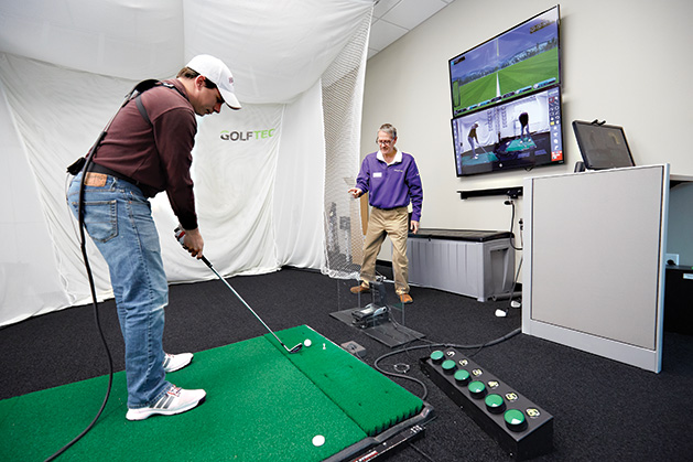 A golfer practices his swing at Golftec.