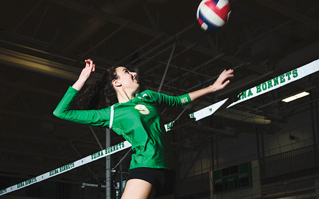An athlete on the Edina High School volleyball team jumps for a spike.