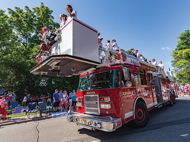 An Edina Fire Department truck rolls down the road as part of the Fourth of July parade.