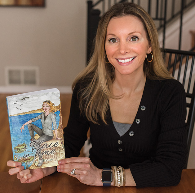 Jacqueline Hanson holds a copy of her first novel, "A Place in Time"