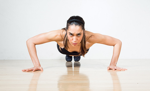 A woman prepares for a perfect push up.