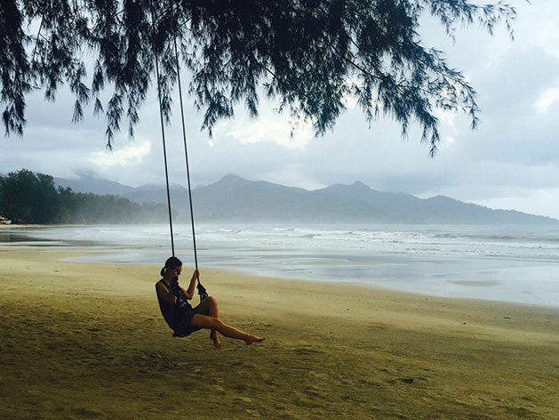 A woman sits on a swing on Klong Prao Beach