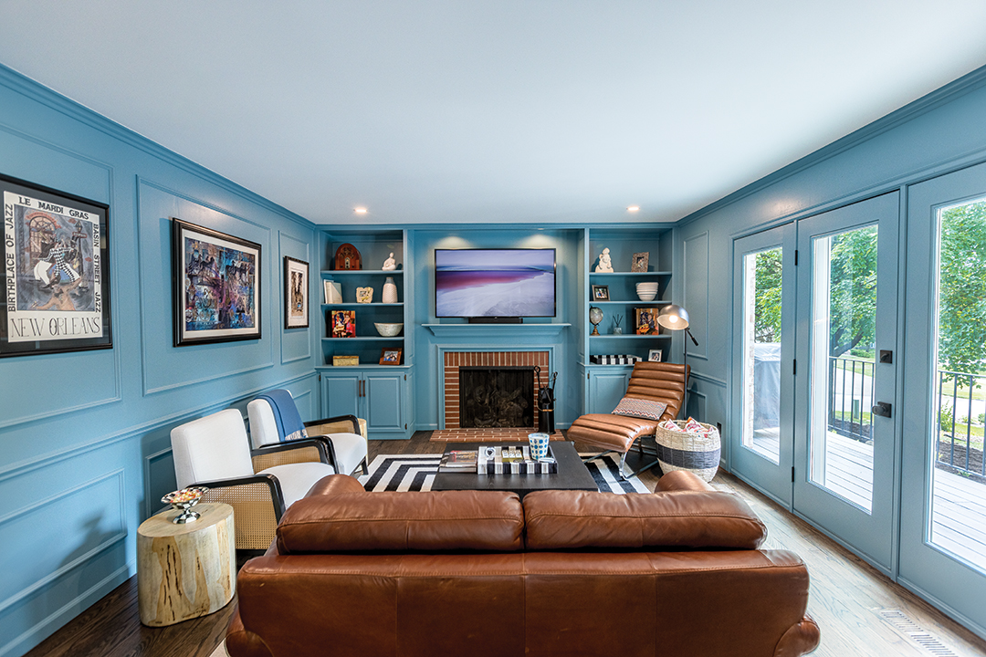 After: The remodeled den with a repaired ceiling. The wood panelling was painted blue and wainscotting remained to add texture. Warm leather accents finish the overall look.