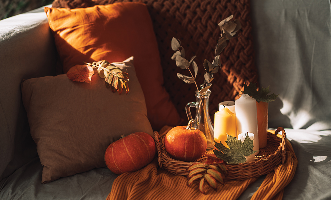 Autumn interior with burning candles and pumpkin.