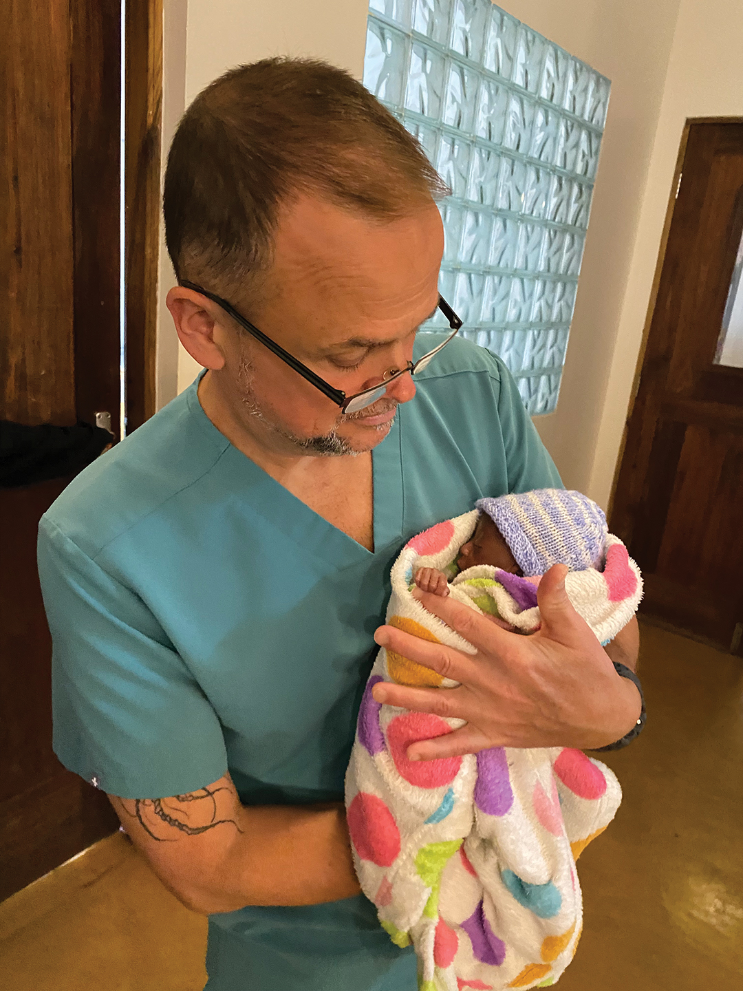 Blaine Caton with a baby whose life he helped save after addressing growth challenges.