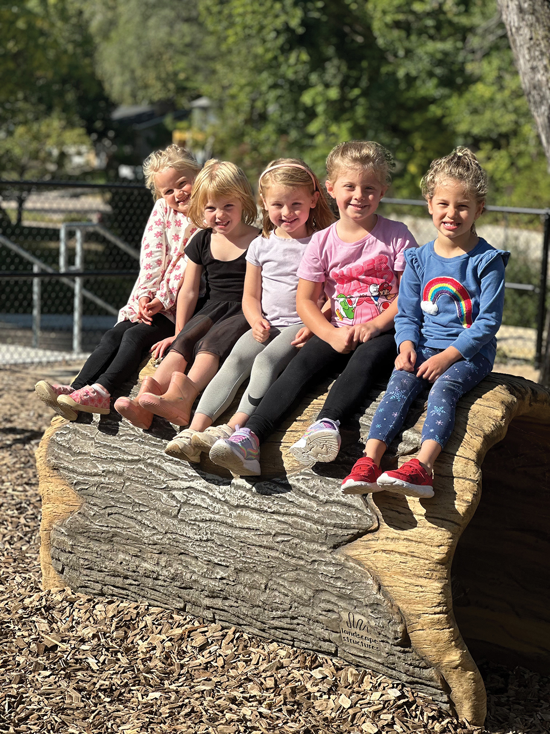 Preschool students take a break on their favorite log in the playground. Photo: Normandale Preschool and Blessing Place