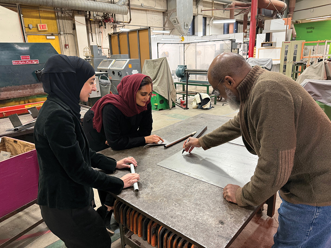 Afira Hasan and Zujaja Sadiq discuss the design of a bench with an arabesque grate with artist Russell Hamilton.