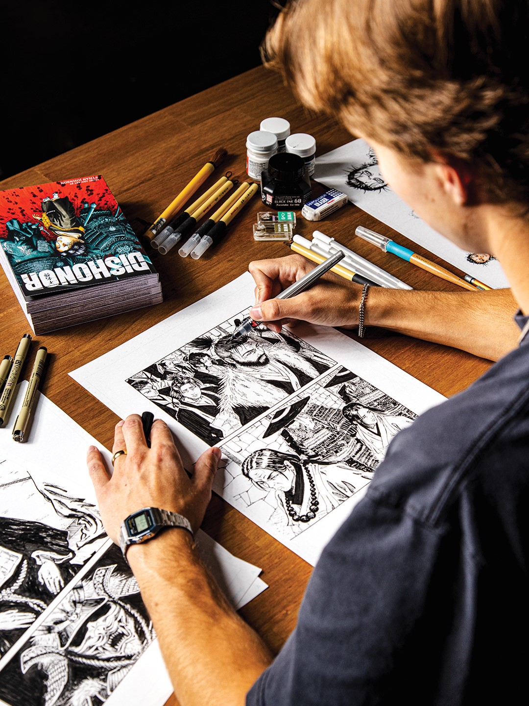Artist Ethan Johnson brings his manga to life from start to finish. He writes, illustrates, inks and letters every page himself. Here he sits at his desk, coloring in the hair of a samurai.