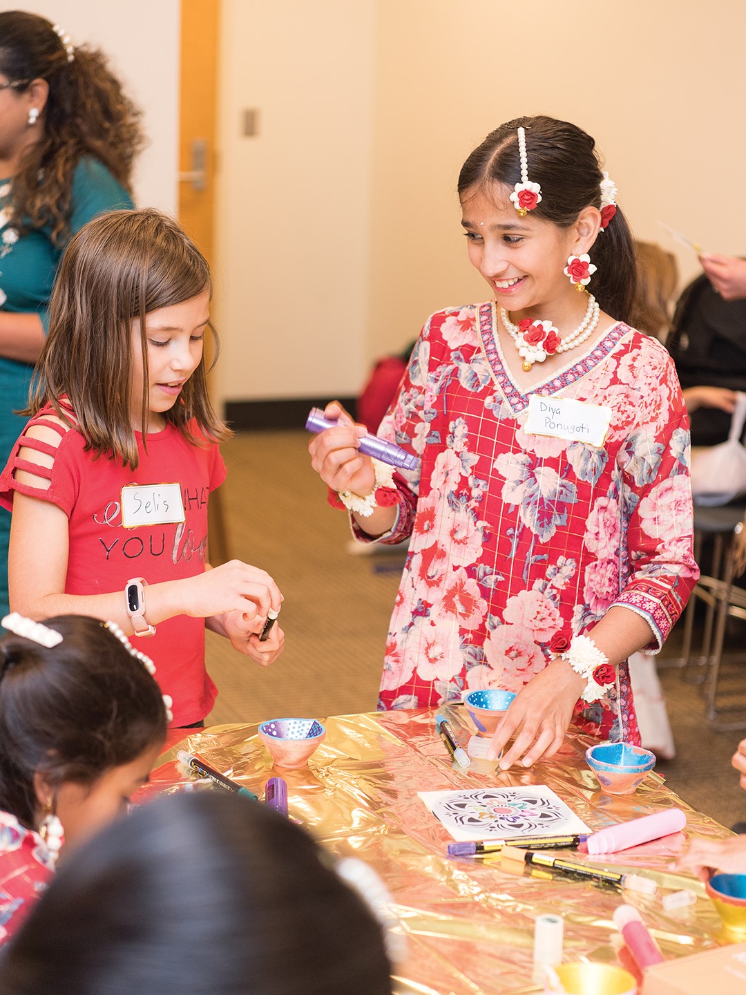 Last year’s Diwali festivities included colorful rangoli (traditional chalk art) created with glitter pens and stencils. Volunteer artists adorned hands with henna. 