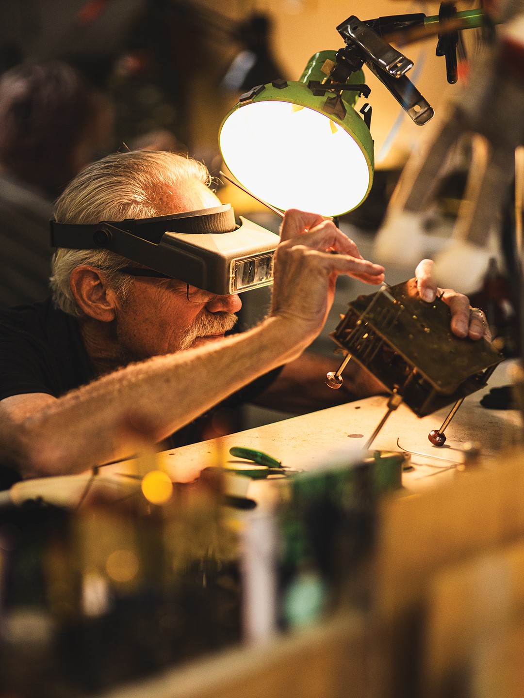 Mark Purdy repairs the inner workings of a clock.
