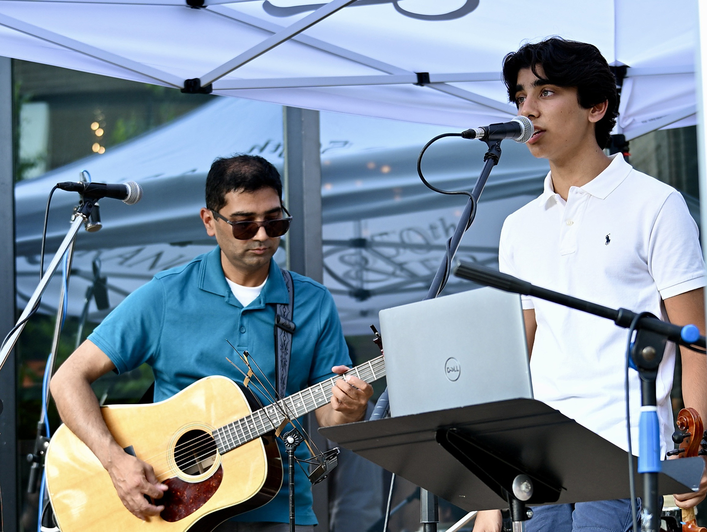 Gaurav Jain playing guitar and Ratik Jain singing.