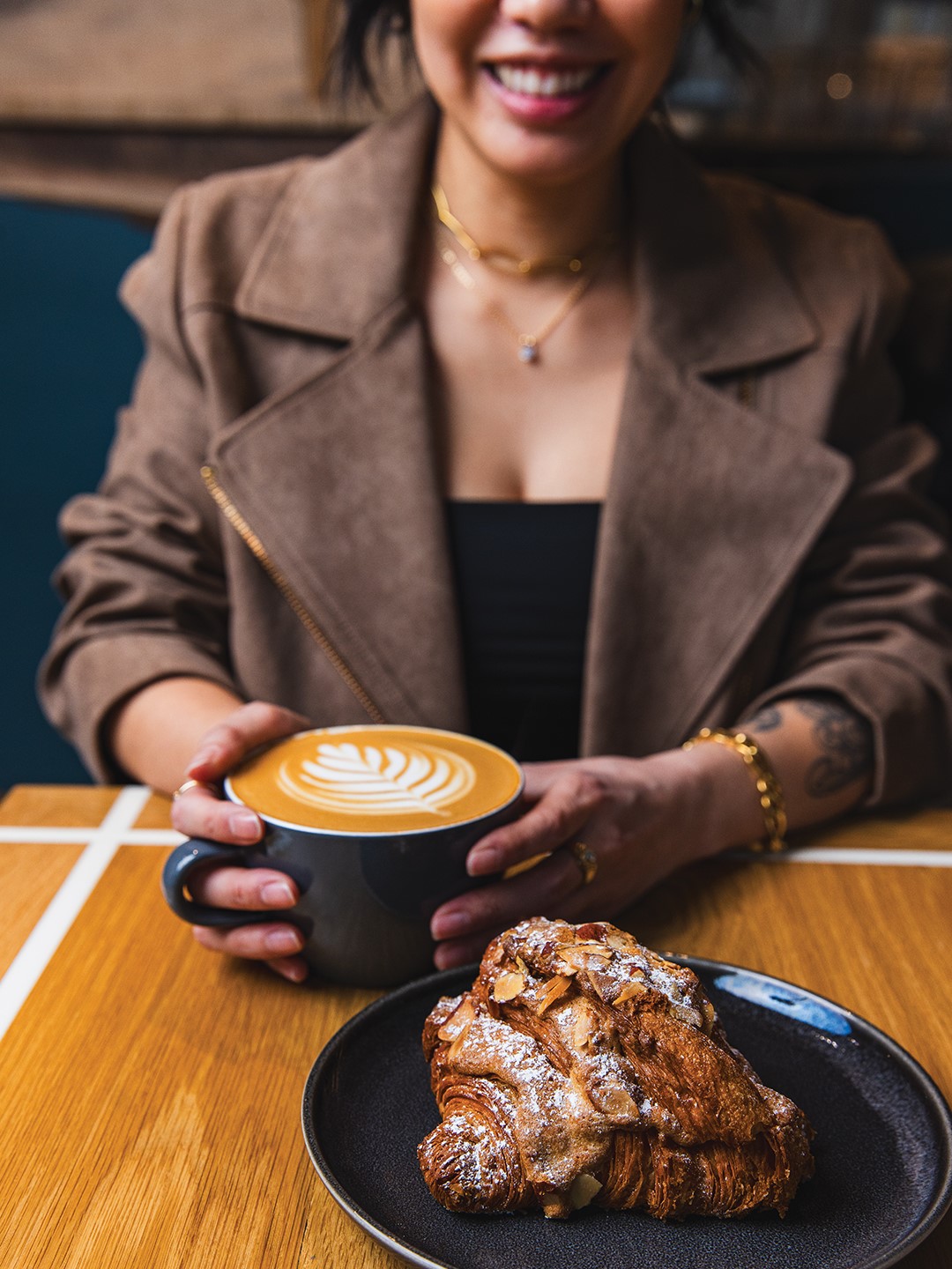 A customer enjoys a latte and an almond croissant. Pastries at The Lobby Coffee & Leisure are made by Patisserie 46.