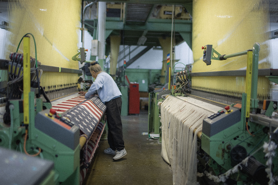 Mary Boudreau at a loom weaving an American Flag Wool Throw.