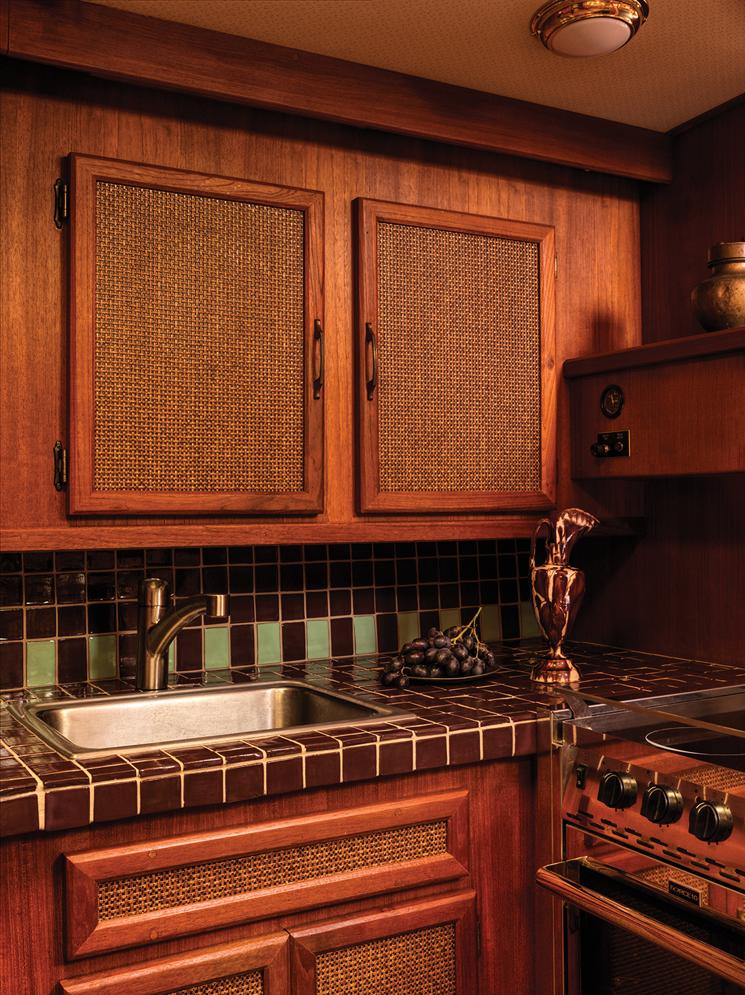 When it comes to tile, Victoria Sass often collaborates with ceramist Kristen Falkirk of Indiana. To create this woodland cabin look for the boat’s kitchen, Falkirk created handmade tiles in shades of black and green. The tiles were installed by Sam Devine of Devine Tileworks.