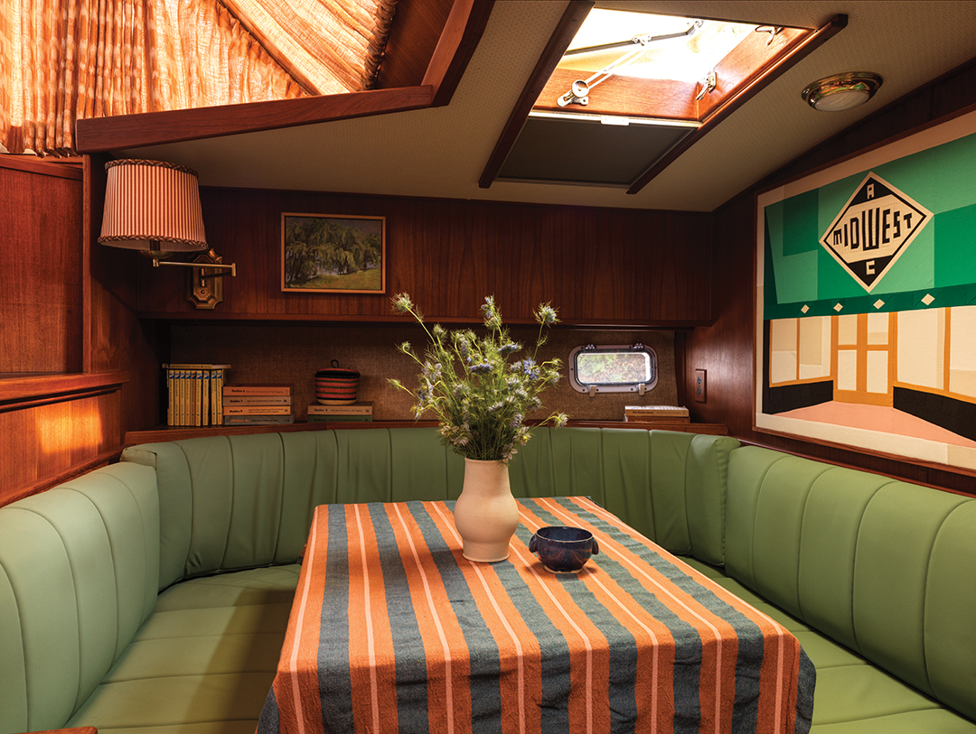 Stripes adorn the table in the seating and dining area. Splashes of green can be found throughout the boat, acting like a unifying thread that intricately weaves together all the elements of design aboard Freya.