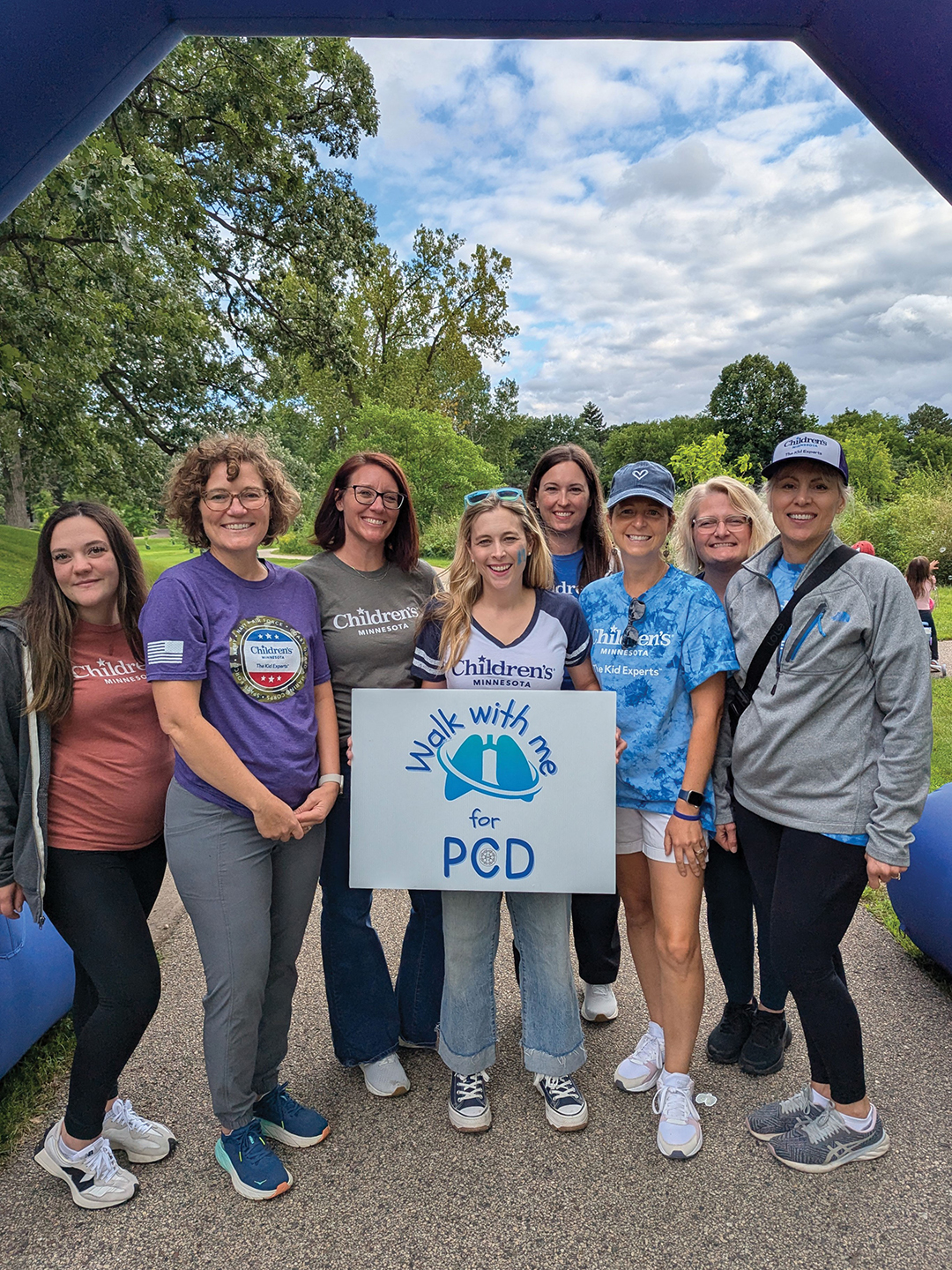 Anne Griffiths, M.D., is seen holding a sign at Walk With Me for PCD, a fundraising event at Rosland Park that took place last August, alongside the team from Children’s Minnesota. The pediatric pulmonologist is an expert on primary ciliary dyskinesia (PCD), a genetic disorder that causes respiratory issues.