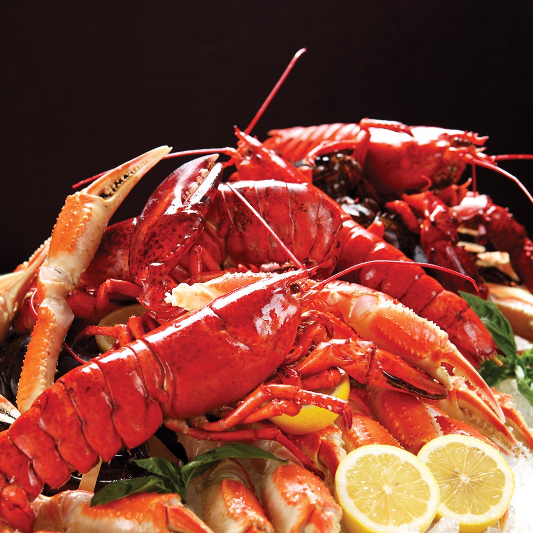 Pile of cooked lobster against a black background