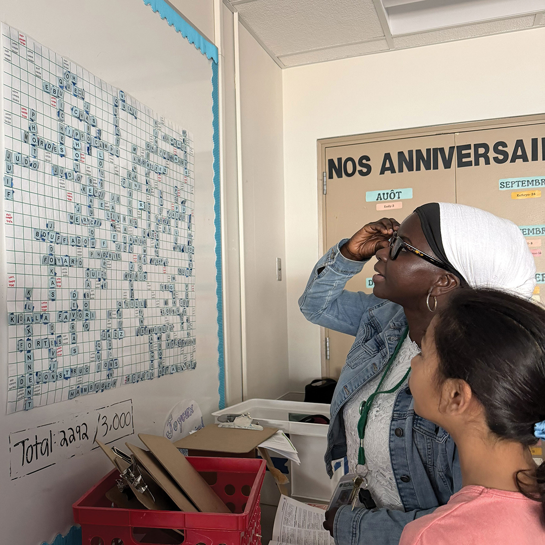 Seck and students play Scrabble on a whiteboard.