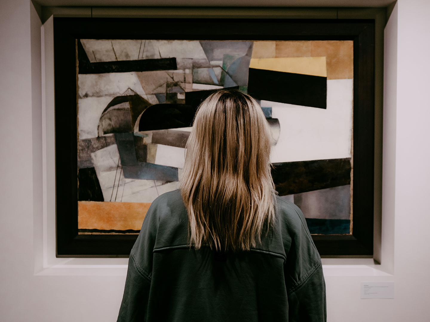 Back view of a woman looking at abstract art