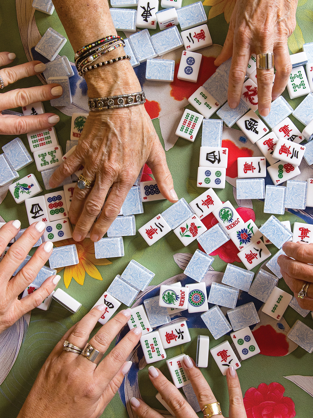 Hands grabbing mahjong tiles