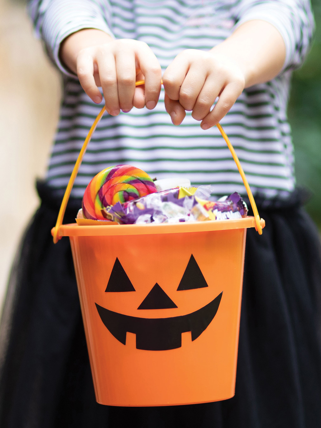 Girl holding Halloween candy bucket